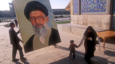 eine Person hält ein grosses Porträt-Bild von Ali Chamenei