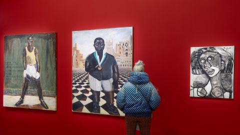 eine Person betrachtet Gemälde in der Ausstellung «Paris noir»