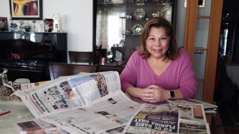 Karen Şarhon sitzt am Tisch und zeigt ihre Monatszeitung «El Amaneser»