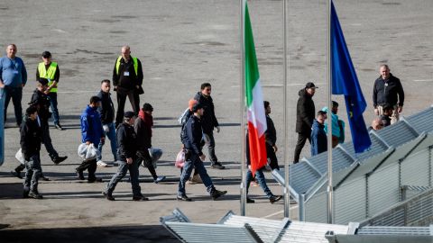 Migranten werden von Polizei und Sicherheitspersonal in ein Lager im albanischen Shëngjin geführt