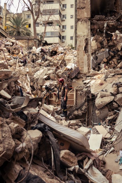 ein Helfer mit Helm steht auf den Trümmern des zerstörten Hauses in Beirut