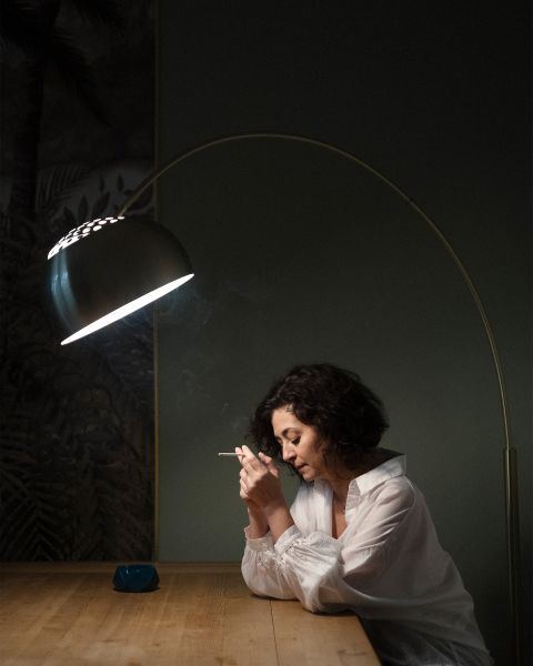 Ece Temelkuran sitzt an einem Tisch und raucht eine Zigarette