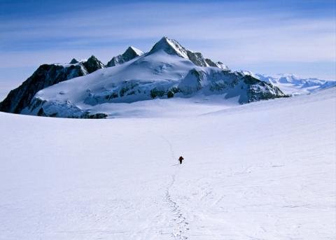Symbolbild: Spur im Schnee von BergsteigerInnen und Bergspitzen im Hintergrund