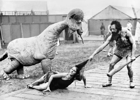 Schauspielerische Darstellung einer Frau, die von ihrem Mann in die Steinzeithöhle zurückgezerrt wird