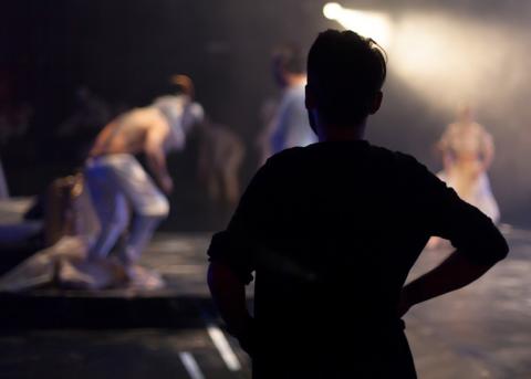 Person im Schatten auf einer Theaterbühne