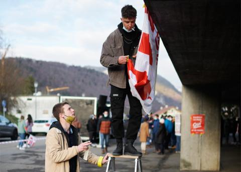 Jonas Girardin (links) hilft einem Kollegen beim Aufhängen einer Jurafahne im oberen Teil von Moutier