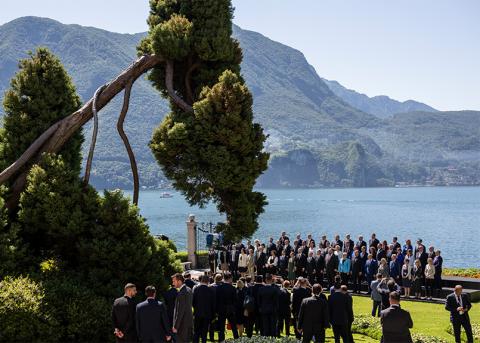 Politiker:innen stehen für ein Gruppenfoto vor dem Luganersee zusammen