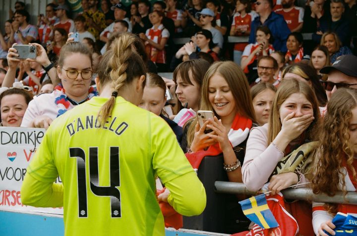 eine Spielerin des Arsenal Women Football Club signiert ein T-Shirt eines weiblichen Fans