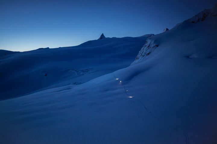 Bergsteiger:innen mit Stirnlampen auf dem Glacier du Mont Miné in den Walliser Alpen