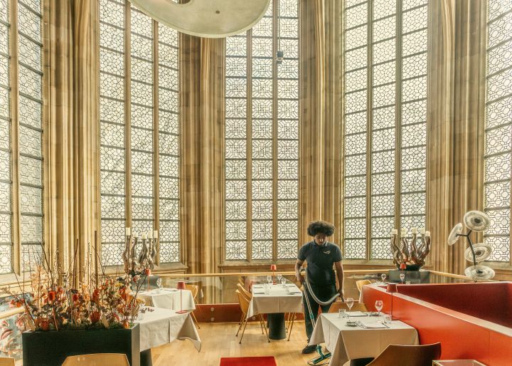 eine Person reinigt mit dem Staubsauger den Boden des Kruisherenhotel in Maastricht, Niederlande