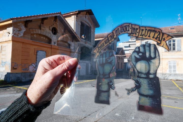 Fotografie einer Folie, auf der ein Graffiti zu sehen ist, im Hintergrund der Platz wo einst das autonome Zentrum stand