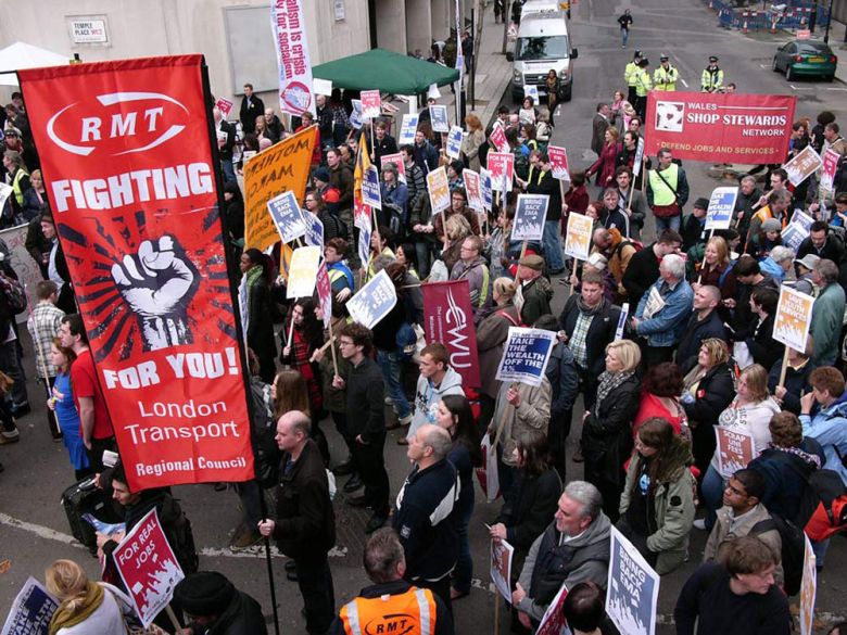 Personen mit Transparenten an einer Protestaktion der Gewerkschaften