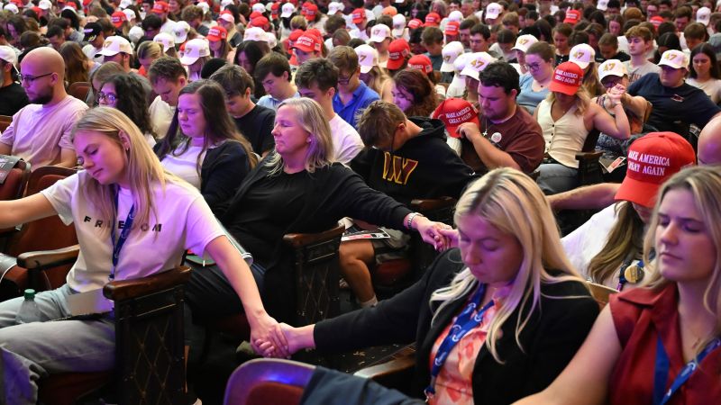 Teilnehmer:innen einer Veranstaltung der Organisation Turning Point USA halten sich an den Hände