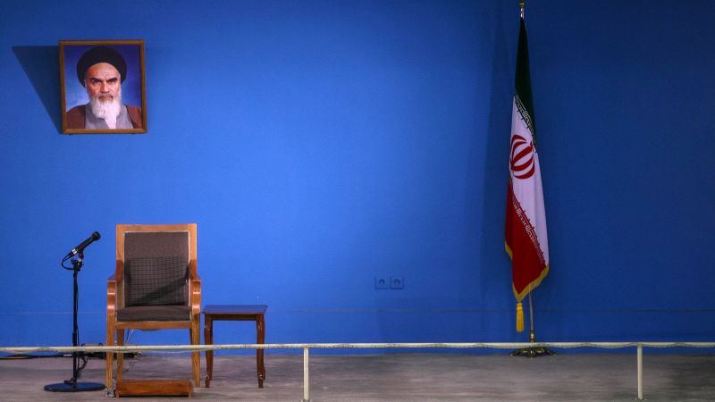 Wand an der ein Porträt von Ruhollah Chomeini hängt, daneben die Iranische Fahne