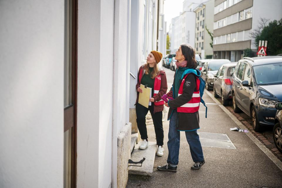 Agnes Jezler unterwegs im Basler St.-Johann-Quartier, wo sie mit einer Person bei einer Haustüre spricht