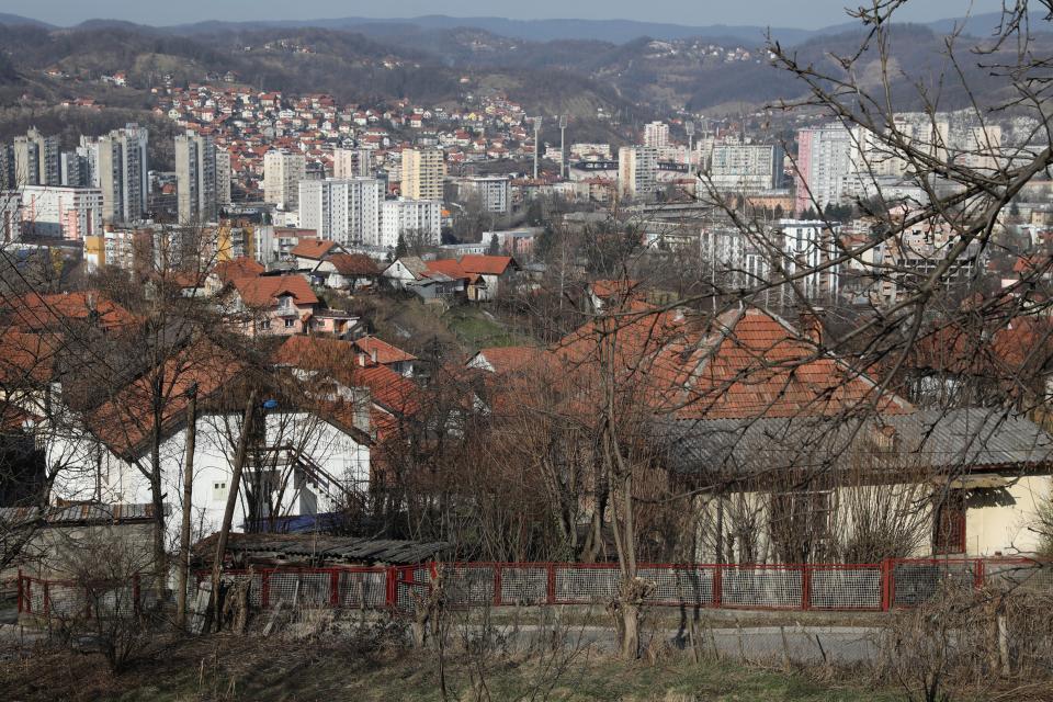 Blick über Hausdächer auf Wohnhochhäuser in Tuzla
