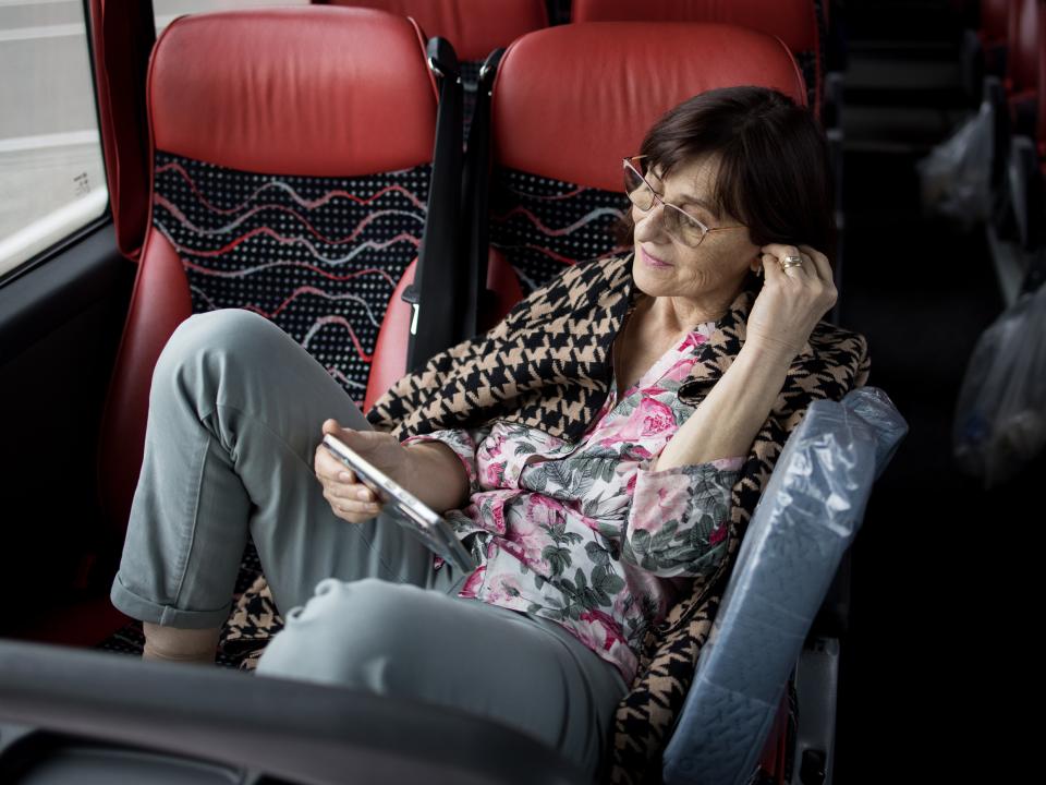 Rosanna Muscalu sitzt im Bus und liest auf dem Tablet