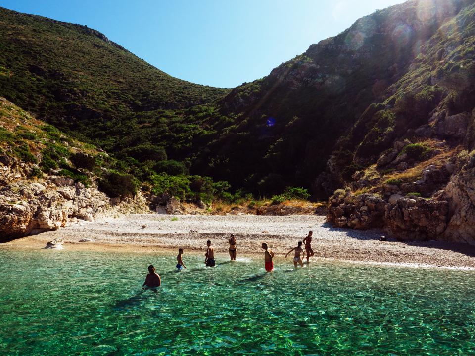 Badende an einen kleinen Kiesel-Strand auf der Halbinsel Karaburun