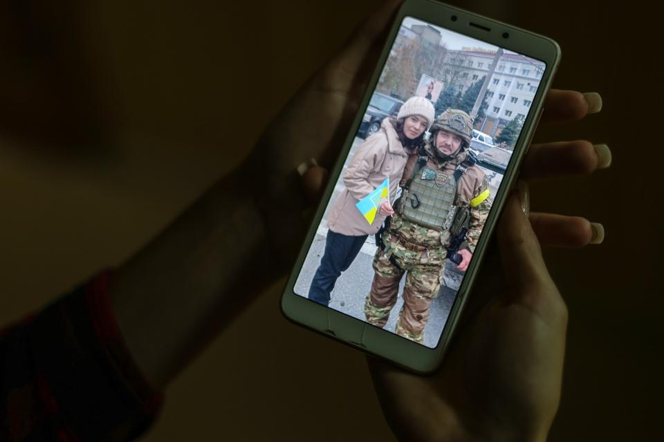 Foto auf einem Smartphone-Bildschirm: Viktoria Jarosch mit einem ukrainischen Soldaten nach der Befreiung der Kleinstadt Antoniwka im November 2022