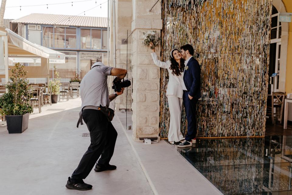ein Fotograf fotografiert ein israelisches Ehepaar nach der Trauung
