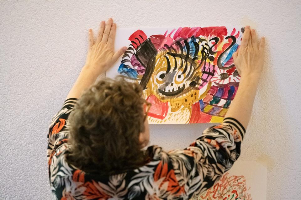 Maya Bringolf hängt ein Aquarell-Bild auf
