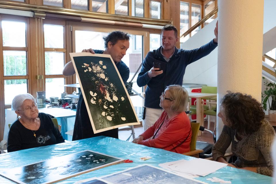 Michael Günzburger zeigt Teilnehmer:innen ein Bild