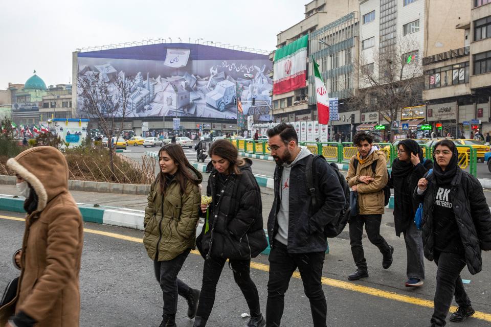 Strassenszene in Teheran Ende Februar, im Hintergrund ein Wandbild das zur Parlamentswahl aufruft