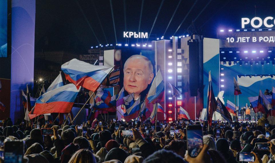 Putins Rede zum Jahrestag der Krim-­Annektierung wird auf einer Leinwand in Moskau übertragen