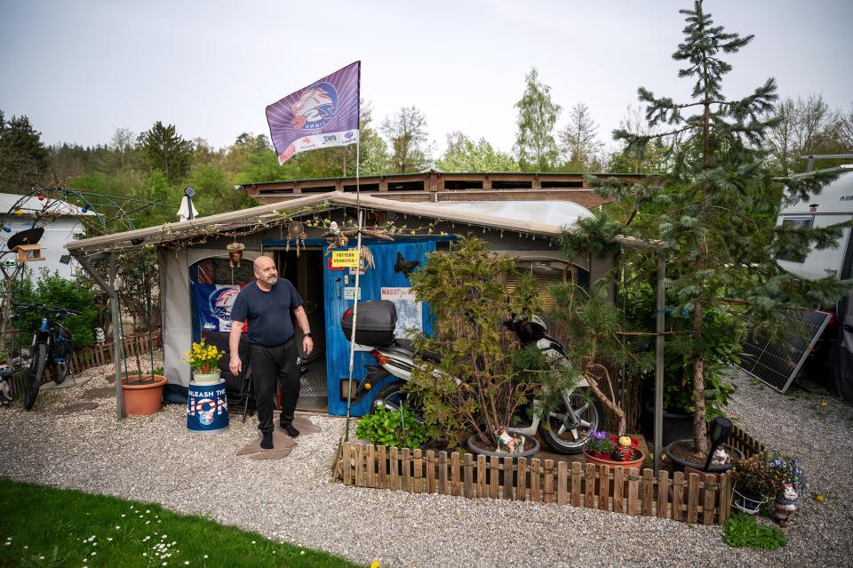ein Bewohner des Campingplatz vor seinem Wohnwagen-Vorbau welcher mit ZSC-Fahnen geschmückt ist