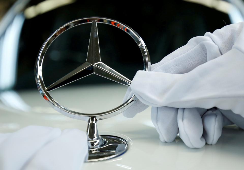 Symbolbild: ein Mercedes-Stern wird auf einem Auto montiert