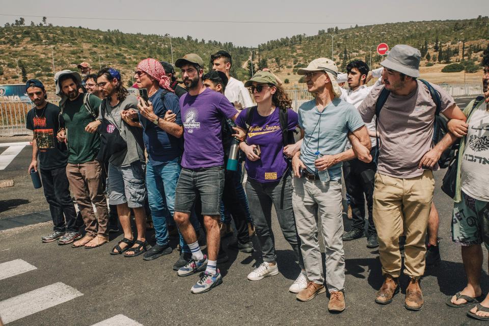 Aktivist:innen von Standing Together schirmen Lkws mit Hilfsgütern für Gaza ab