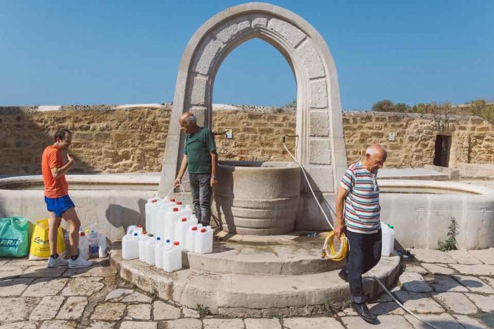 Bewohner füllen Wasser in Kanister am Bonamorone-Brunnen in Agrigent