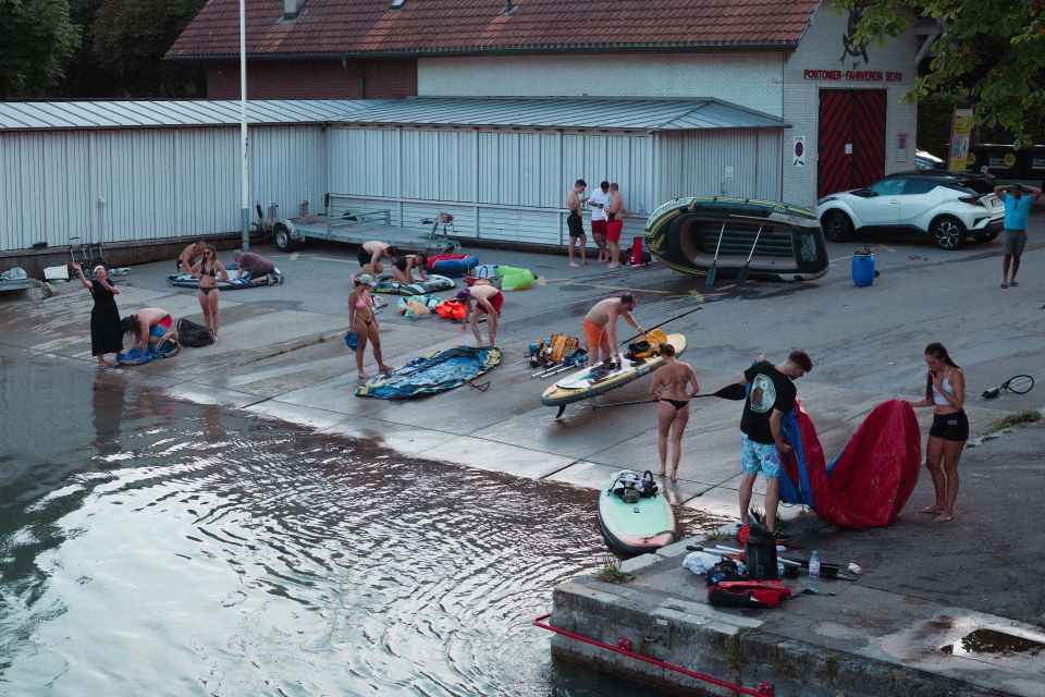 mehrere Personen verräumen Boote und SUPs bei der Auswasserungsstelle in Bern Marzili