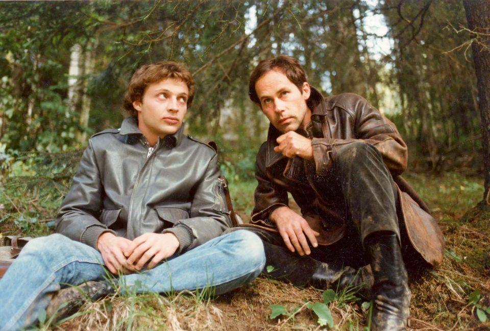 Filmstill aus «No Man’s Land»: zwei Männer sitzen am Boden in einem Wald