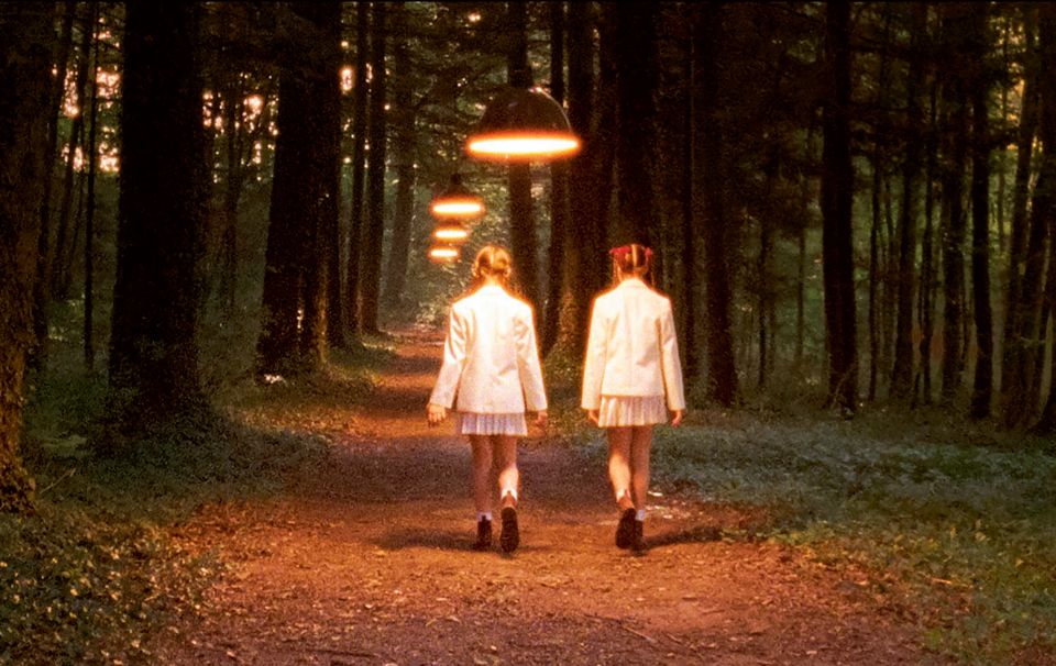 Filmstill aus «Innocence»: zwei Mädchen laufen auf einem Weg im Wald