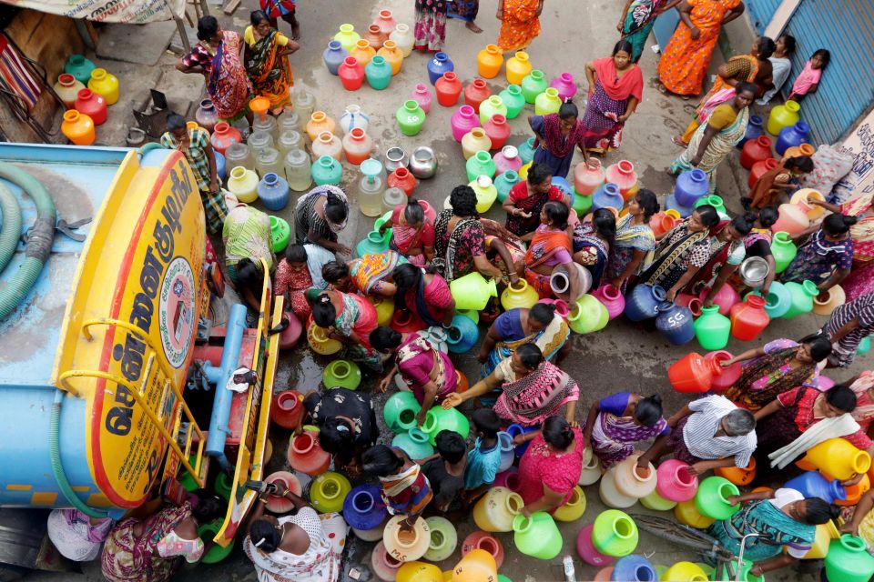 Menschen stehen für die Wasserausgabe an einem Tanklastwagen in der indischen Stadt Chennai an