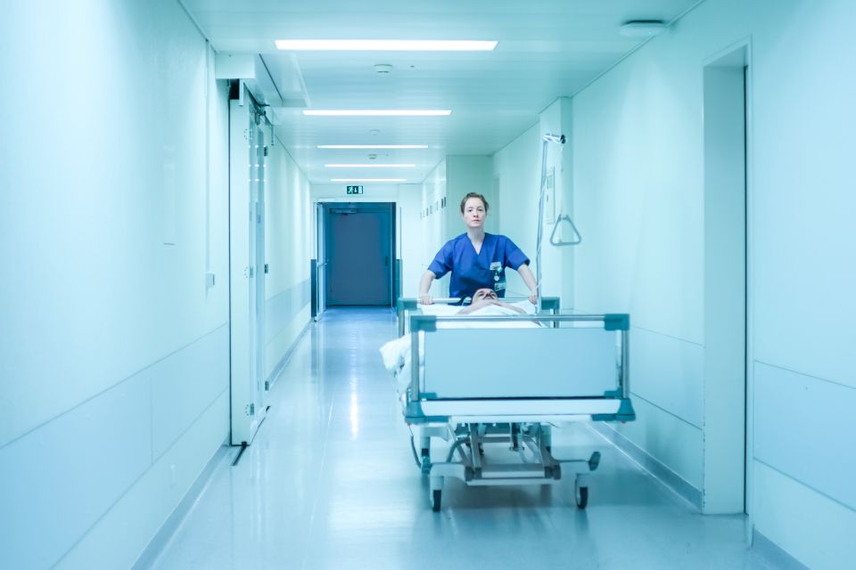 Filmstill aus «Heldin»: eine Krankenpflegerin schiebt ein Spitalbett mit einem Patienten