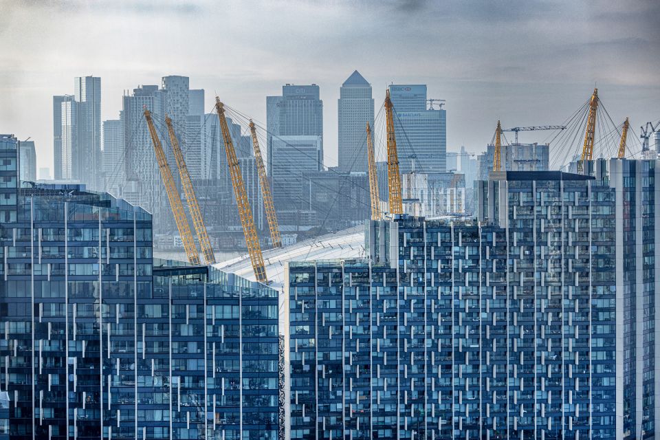 Wohnblocks im East End, dahinter der Millennium Dome und der Finanzdistrikt Canary Wharf