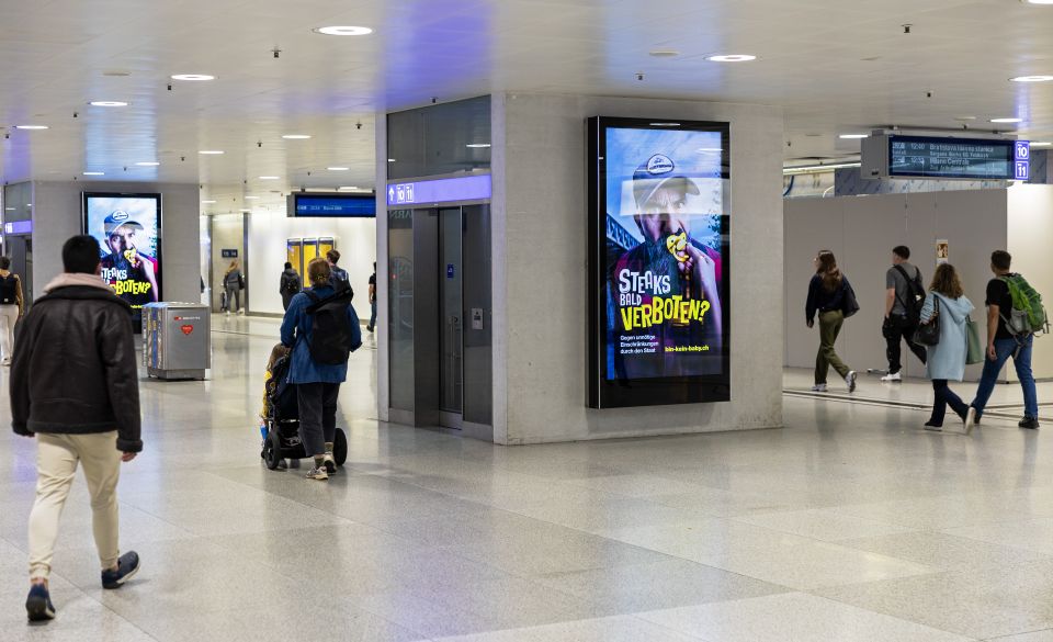 elektronische Plakatwand mit dem «Nuggikampagne»-Plakat im Zürcher Hauptbahnhof