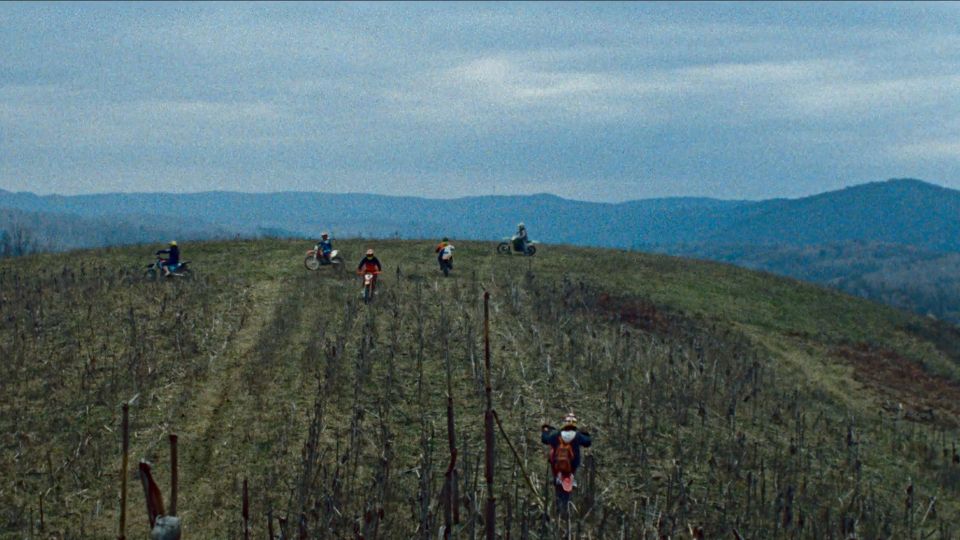 Still aus dem Film The Landscape and the Fury»: Motocross-Fahrer:innen auf einer Wiese