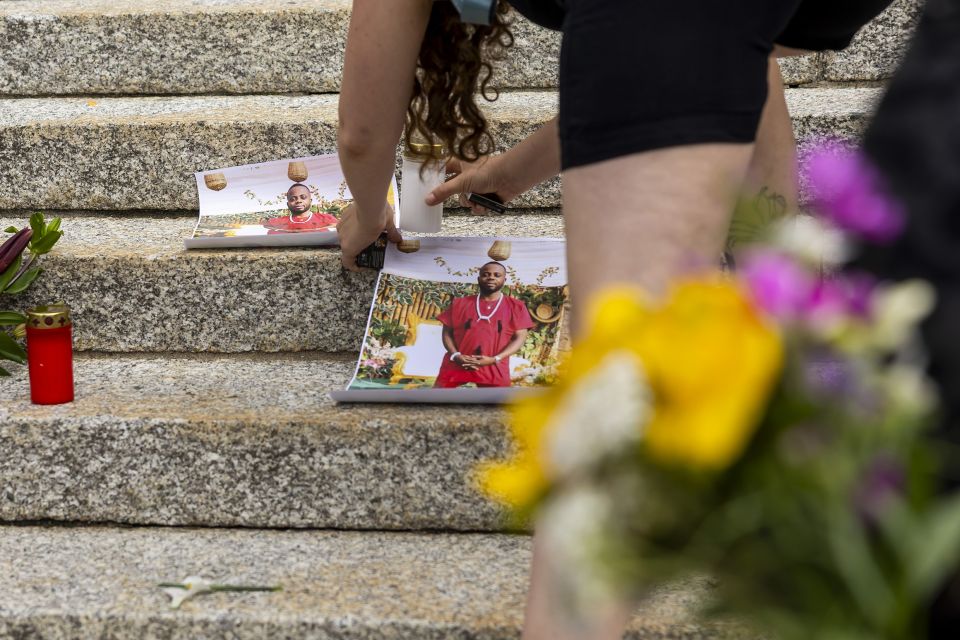 eine Person legt an der Kundgebung am 3. Juni ein Foto von Michael Kenechukwu Ekemezie vor dem Bezirksgericht Lausanne nieder