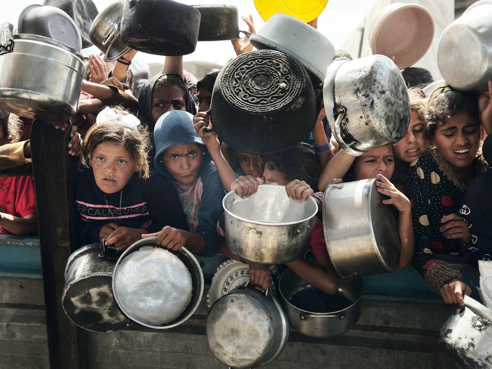 Kinder in Gaza warten mit leeren Töpfen auf die Verteilung von Lebensmitteln