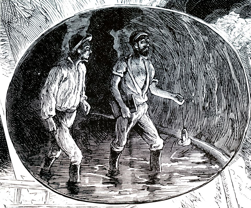 zwei Arbeiter mit einer Tunnellampe im Tunnel