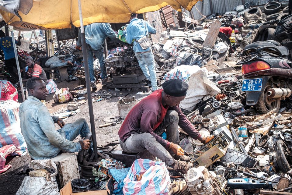 ein Mann sucht in Accra in alten Computern nach Wiederverwertbarem