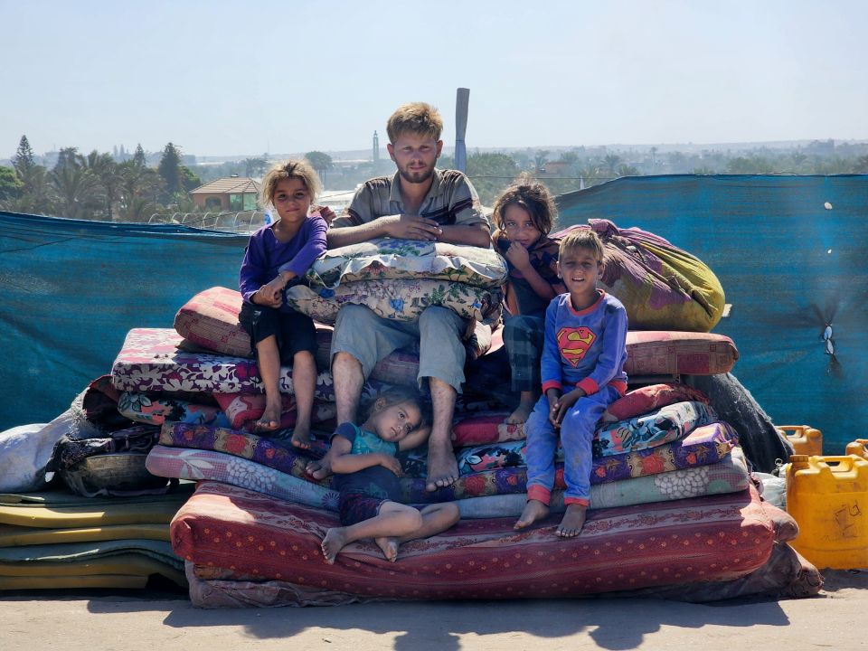 Amir al-Siksik wartet mit seinen Schwestern und seinen Cousins auf einem Stapel Matrazen