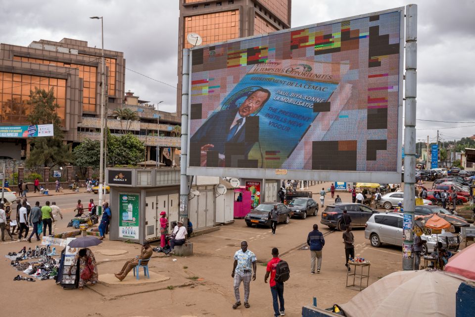 grosse Videowand mit dem Abbild des Präsidenten Paul Biya an einem belebten Platz in der Hauptstadt Jaunde
