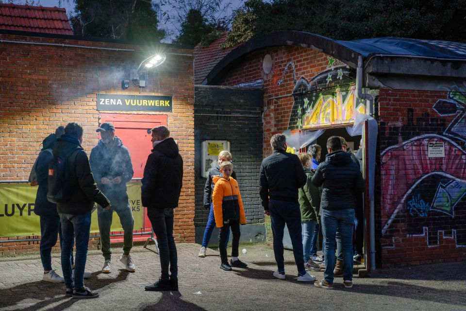 mehrere Personen stehen vor einem Feuerwerks­geschäft im belgischen Baarle-Hertog