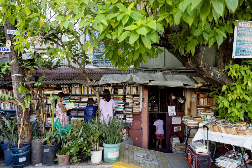 Kinder schauen Bücher an bei einer privaten Gemeindebibliothek in der Stadt Makati bei Manila
