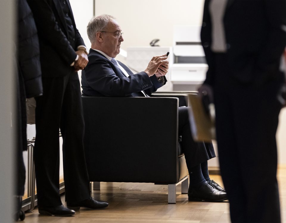 Bundesrat Guy Parmelin schaut auf sein Smartphone