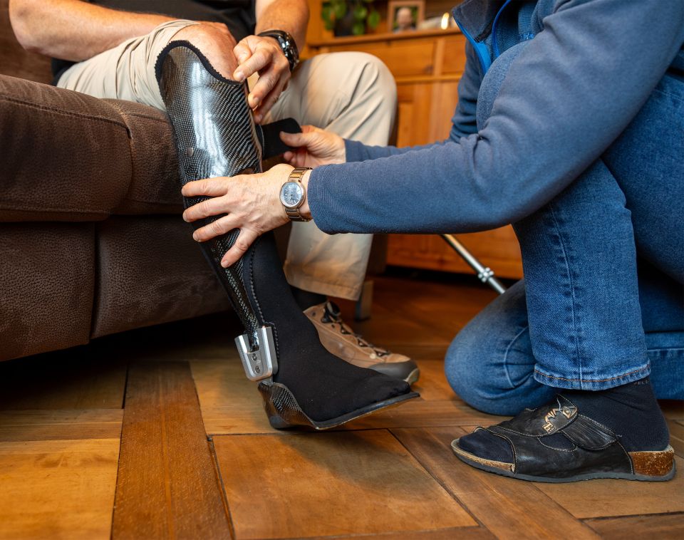 Ursula Schwarzentruber hilft ihrem Partner beim Anziehen der Unterschenkel-Orthese